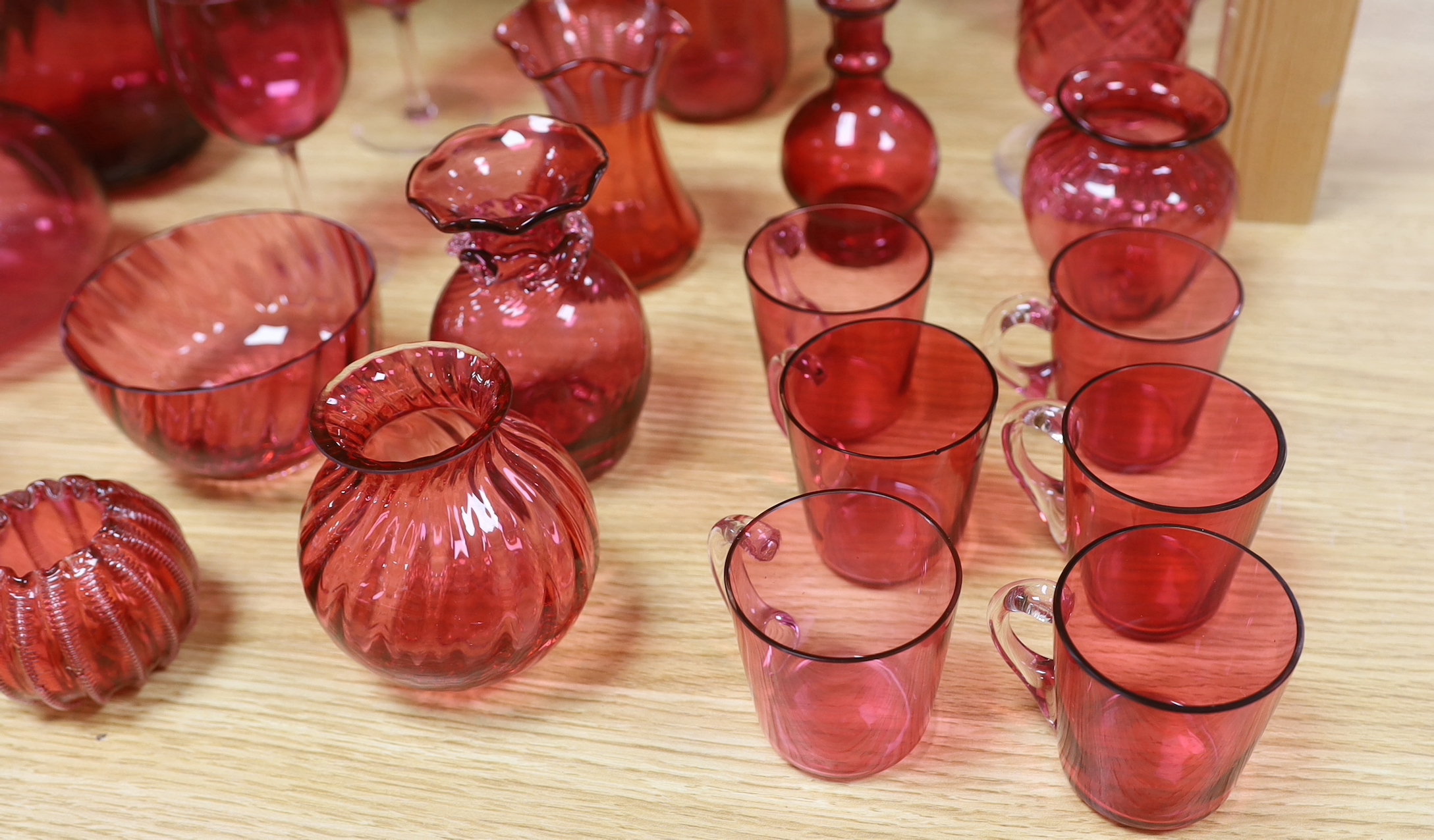 Cranberry glassware including vases, jugs, bowls and custard cups, the largest 33cm high